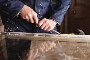 Restoration of old sash windows - wooden frames are scraped from old patty and paint.