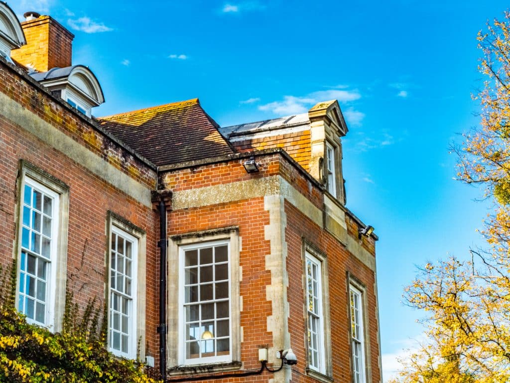 Windows and roof of red brick and stone mansion England UK