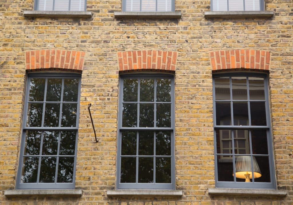 the front of a house with a lamp in the window